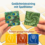 Zwei Hände halten Bildkarten mit Pfauenfeder und Aloe-Spirale – Memospiel Kunstvoll trainiert Aufmerksamkeit, Merkfähigkeit und Konzentration