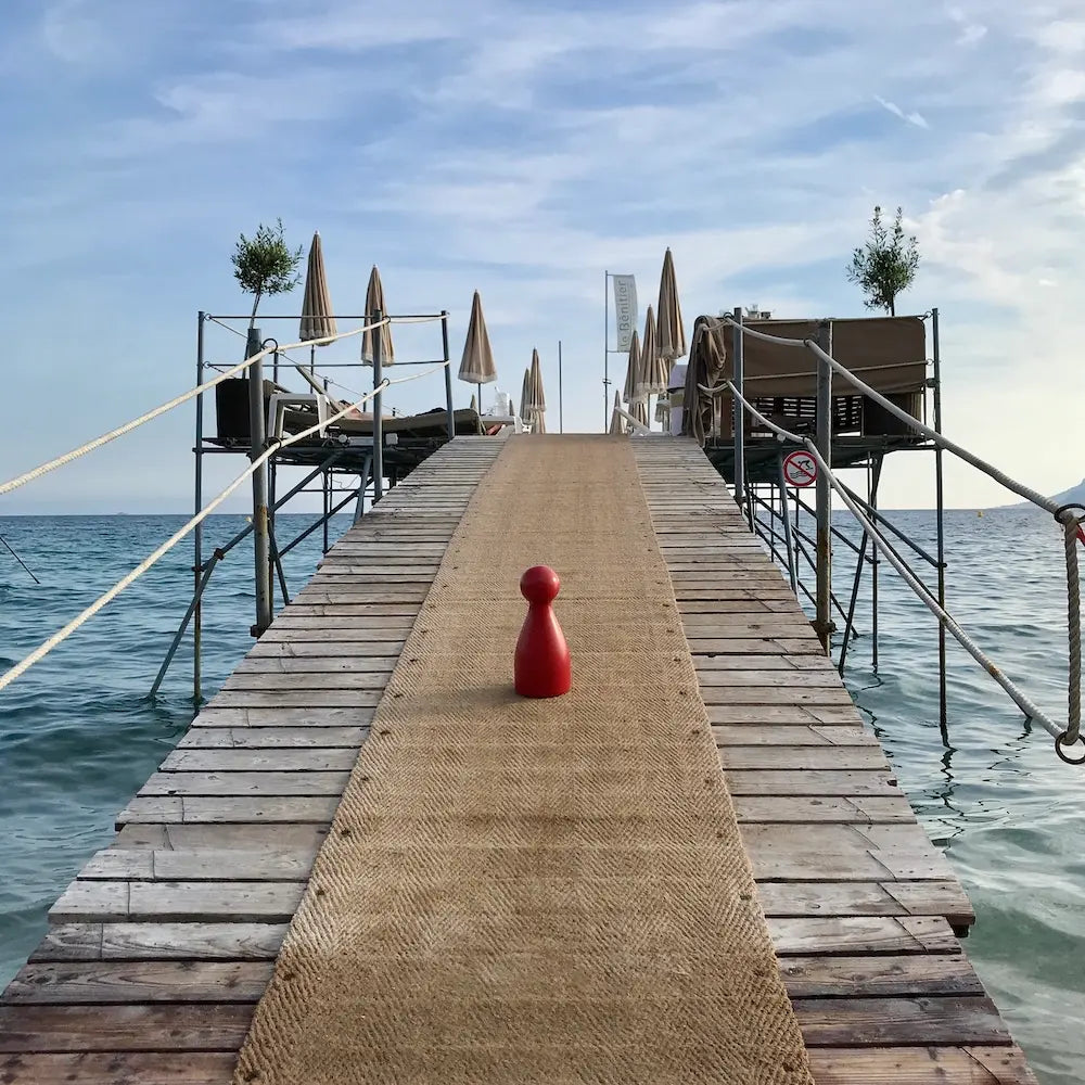 Ms. Meeple auf dem Zugangssteg zu einem Restaurant in Cannes an der Côte d'Azur