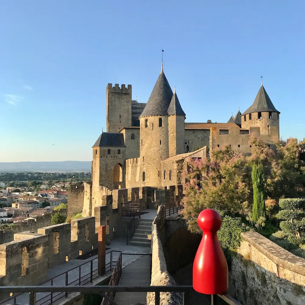 Ms. Meeple vor der mittelalterlichen Festungsstadt Carcassonne in Südfrankreich