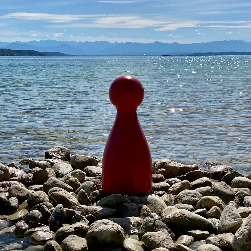 Ms. Meeple am Ufer des Starnberger Sees in Possenhofen mit Blick auf die Alpen