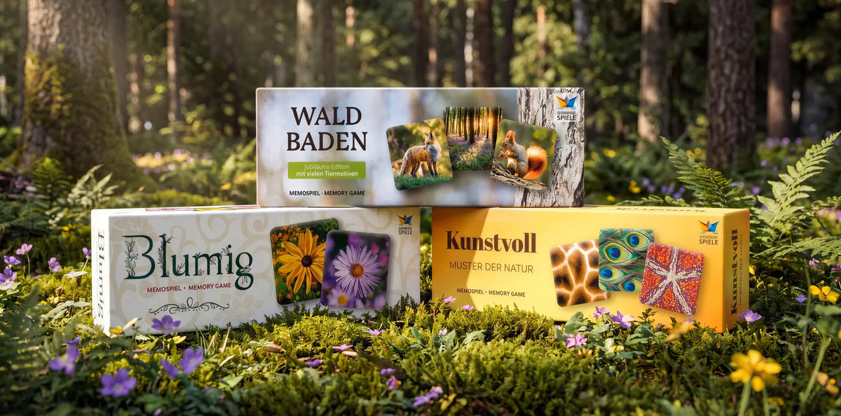 Drei Memospiele von Starnberger Spiele – Waldbaden, Blumig und Kunstvoll – dekorativ arrangiert auf Moos und Blumen in einem Wald. Die hochwertigen Spieleschachteln zeigen verschiedene Naturmotive.
