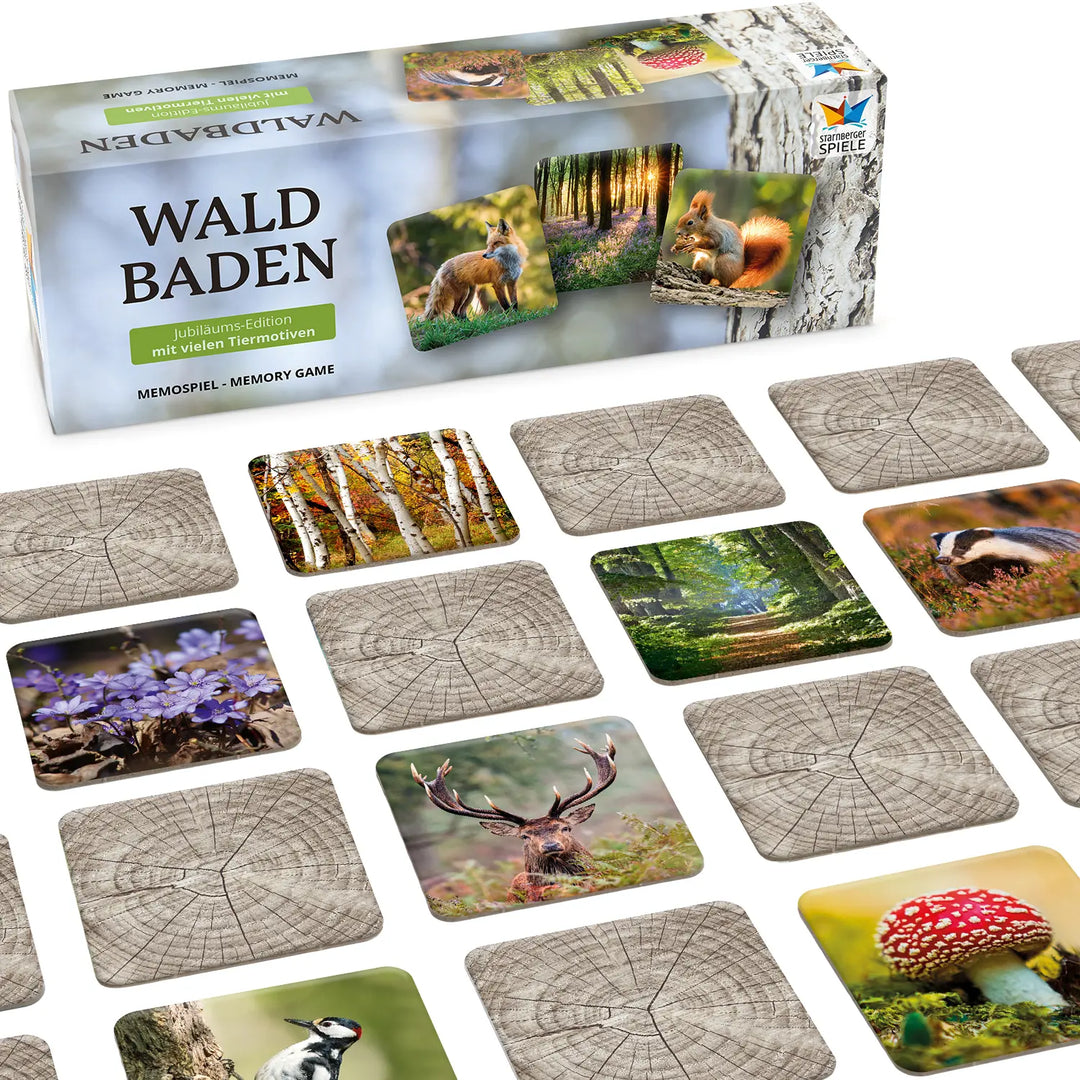 Memospiel „Waldbaden – Jubiläums-Edition mit vielen Tiermotiven“ von Starnberger Spiele mit ausgelegten Karten. Zu sehen sind Motive wie Rothirsch, Dachs, Fliegenpilz und Leberblümchen, dazwischen verdeckte Karten mit Holzmaserung.